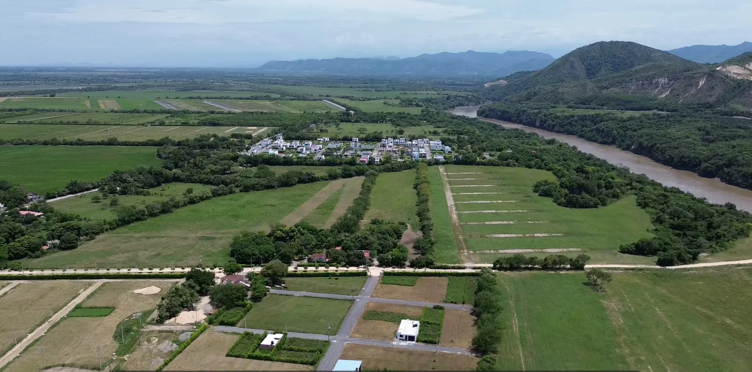 Vista aérea real da região da Urbanización La Florida, com o rio e as montanhas ao fundo